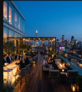 A rooftop terrace overlooking a city skyline at dusk